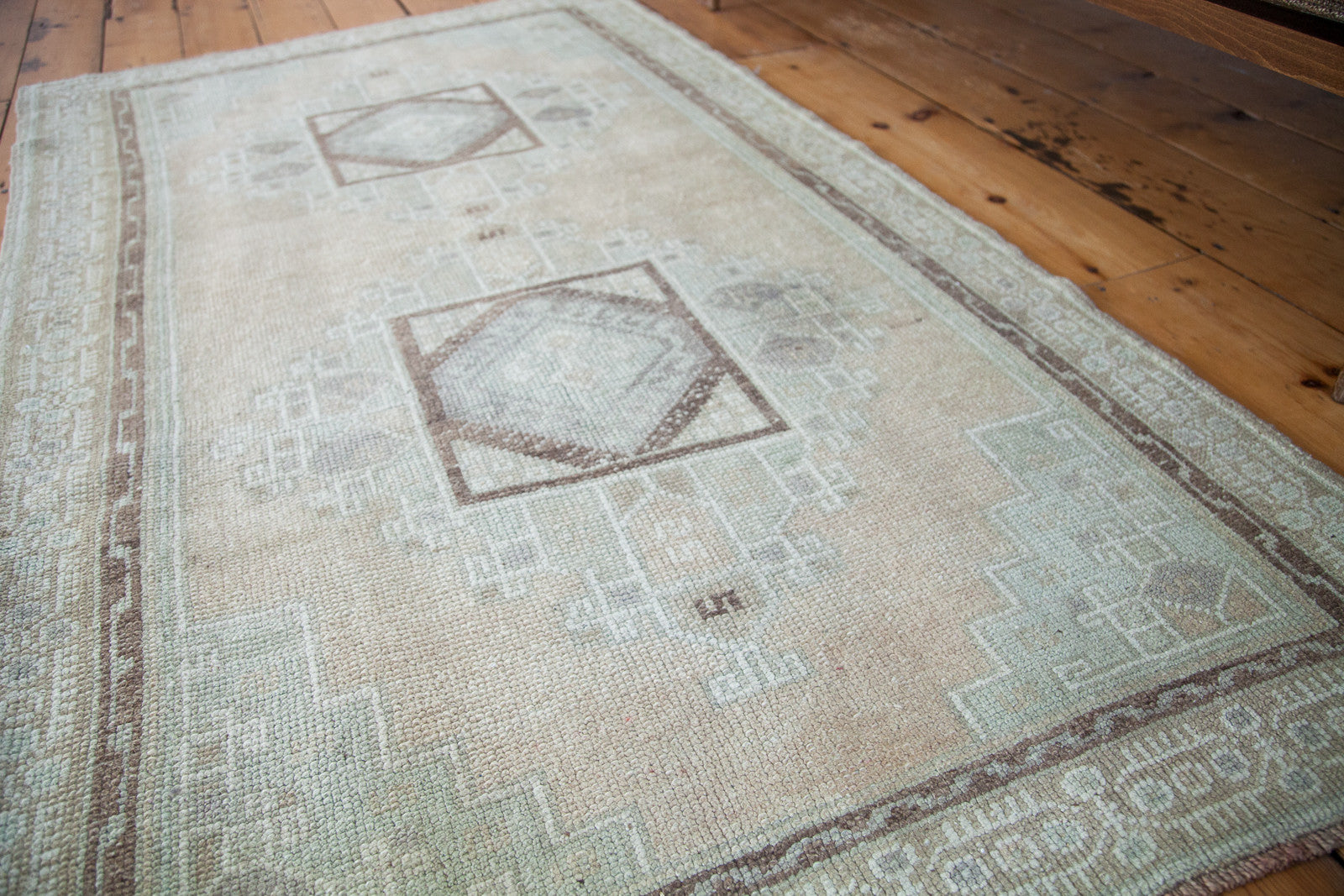 Vintage Oushak rug featuring geometric double medallion with peach field and mint green spandrels.
